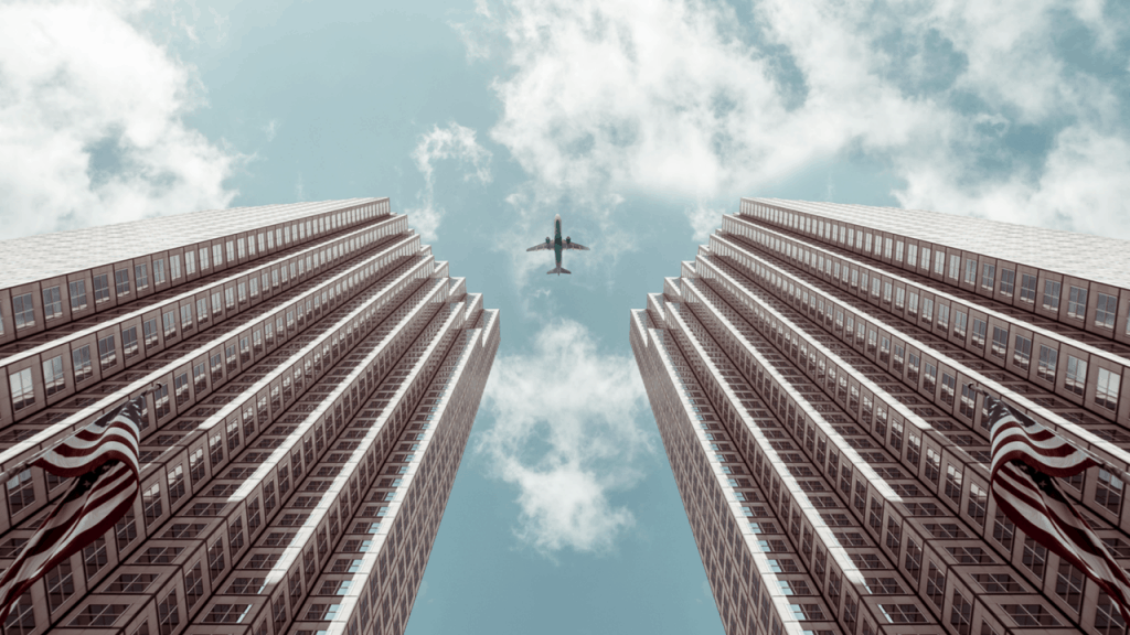 Plane flies between two tall business buildings