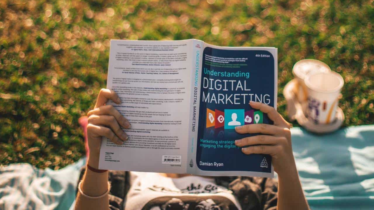 A woman in a park reading about digital marketing